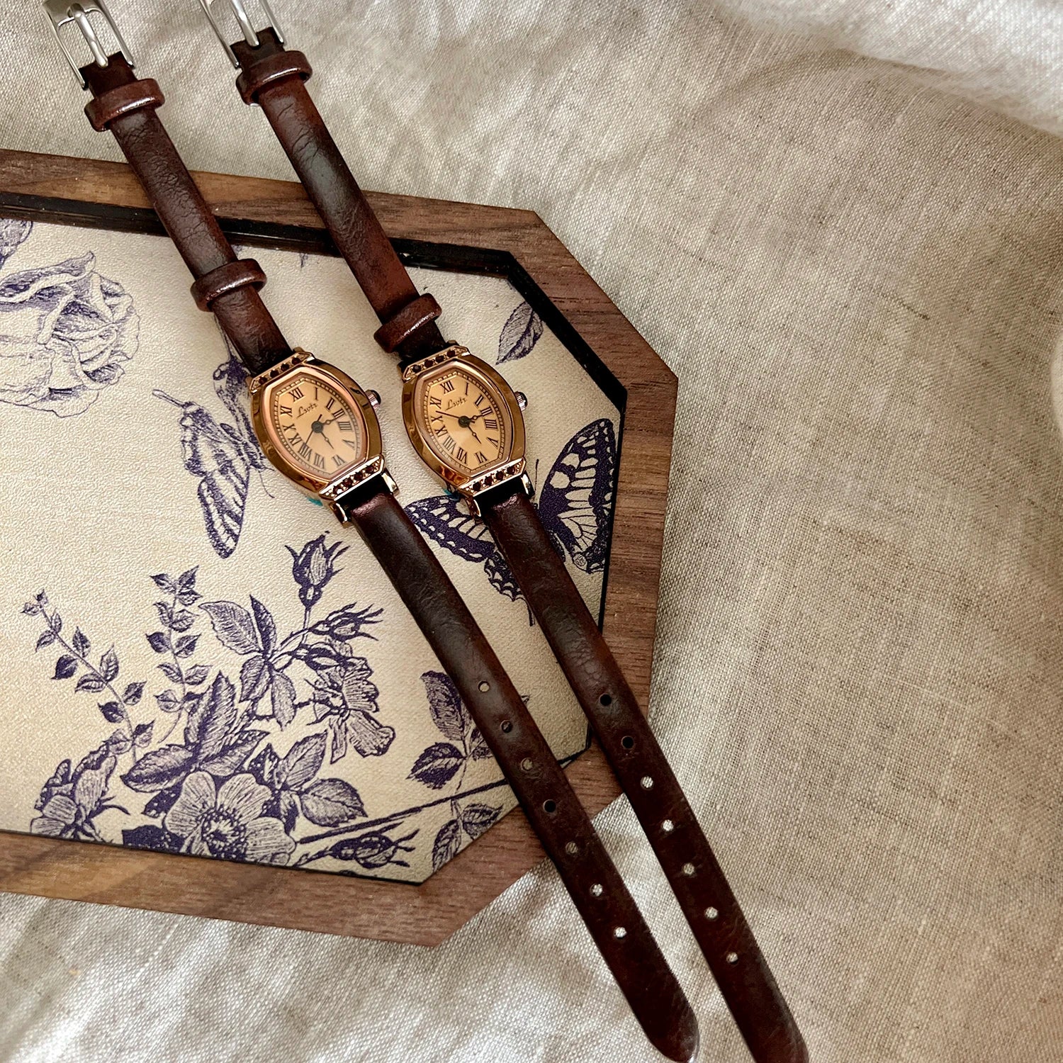 A classic watch with a brown leather strap and decorated with rhinestones.