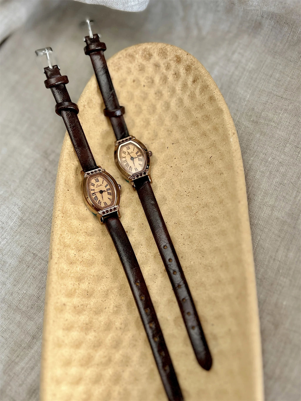 A classic watch with a brown leather strap and decorated with rhinestones.