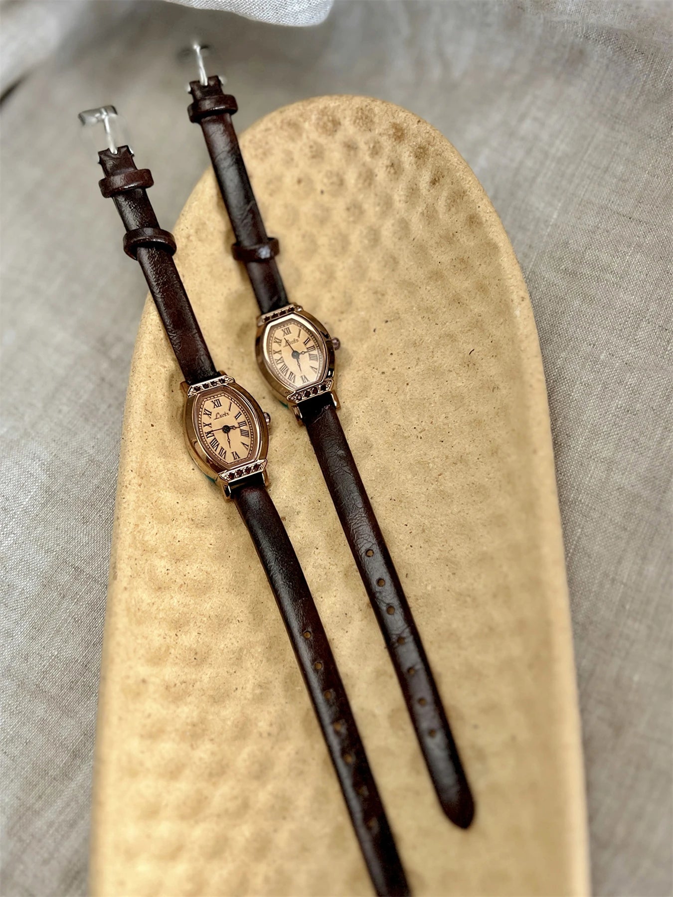 A classic watch with a brown leather strap and decorated with rhinestones.