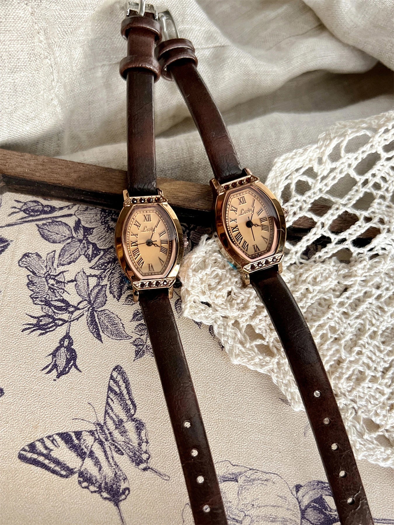 A classic watch with a brown leather strap and decorated with rhinestones.