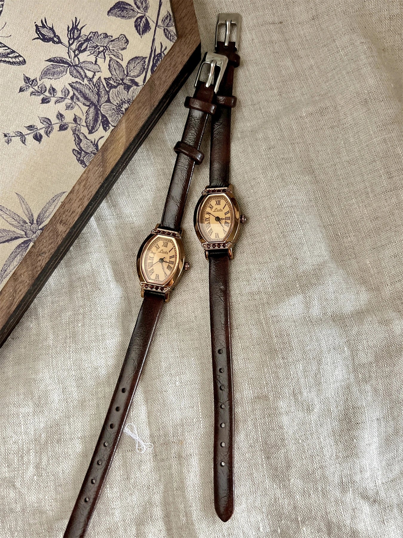 A classic watch with a brown leather strap and decorated with rhinestones.